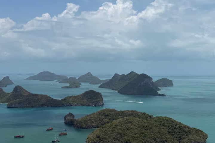 Scenic view of ocean islands with lush greenery under a cloudy sky.