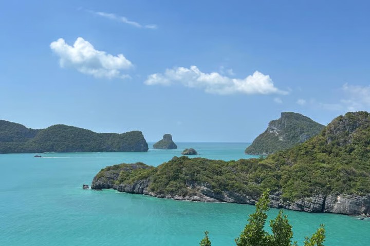 Scenic view of turquoise sea with lush islands under a clear blue sky.